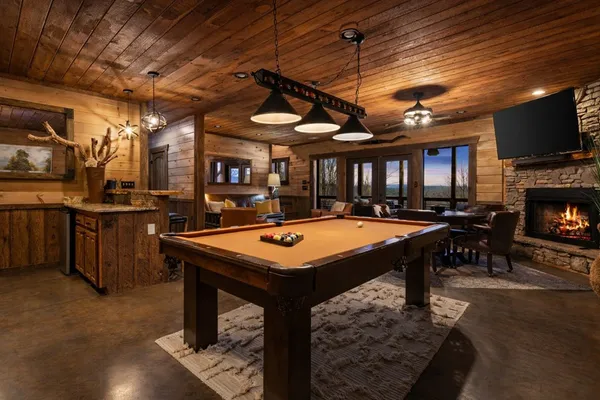 a room with furniture pool table flat screen tv and a rug