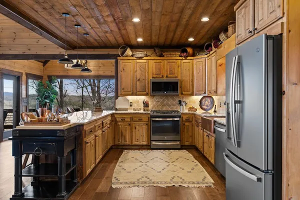 a kitchen with kitchen island granite countertop a sink appliances and cabinets