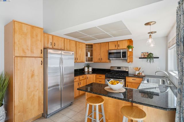 a kitchen with stainless steel appliances granite countertop a stove a sink and a refrigerator