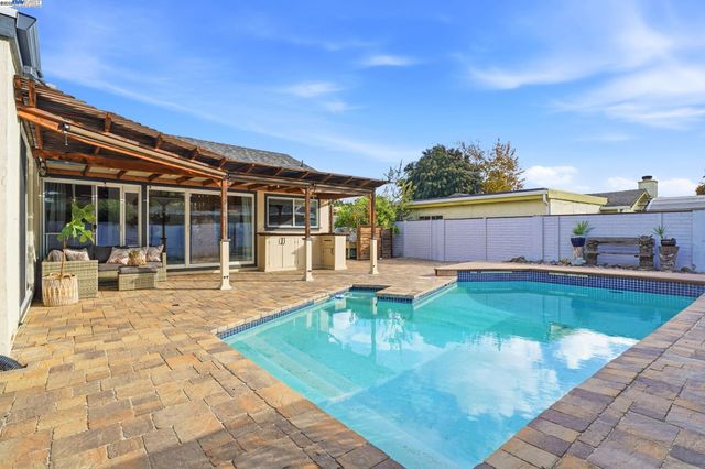 a view of house with swimming pool outdoor seating
