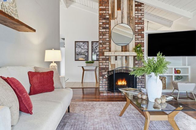 a kitchen with stainless steel appliances granite countertop a refrigerator a stove and a sink with wooden floor