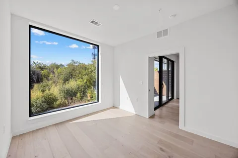 a view of a hallway with wooden floor and entryway