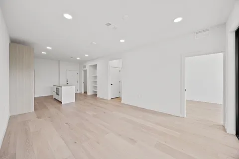 a view of empty room with a kitchen