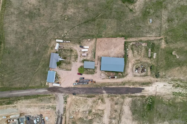 a aerial view of a house with a yard and sitting area