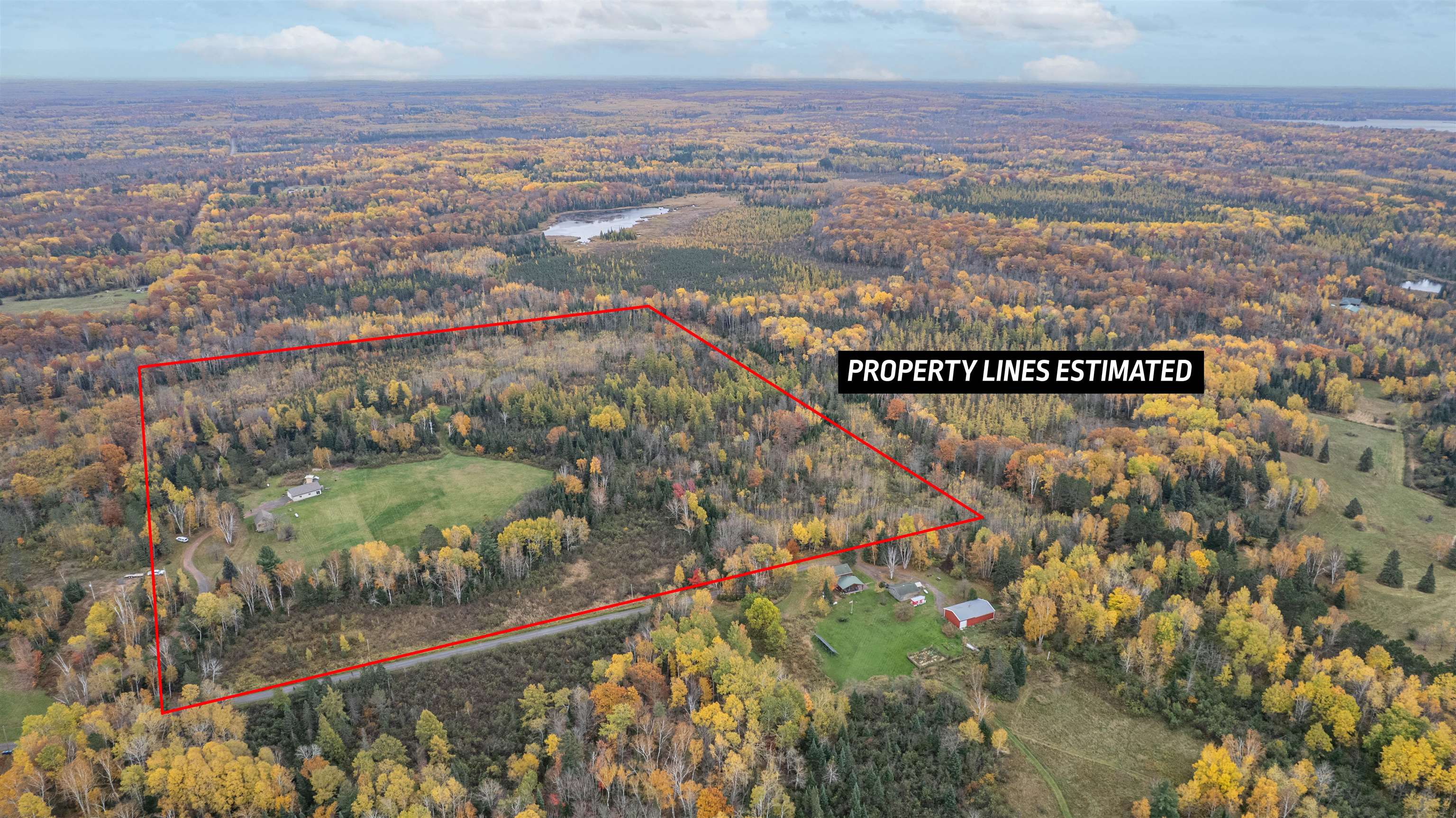 Aerial view of property and surrounding area featuring a heavily wooded area