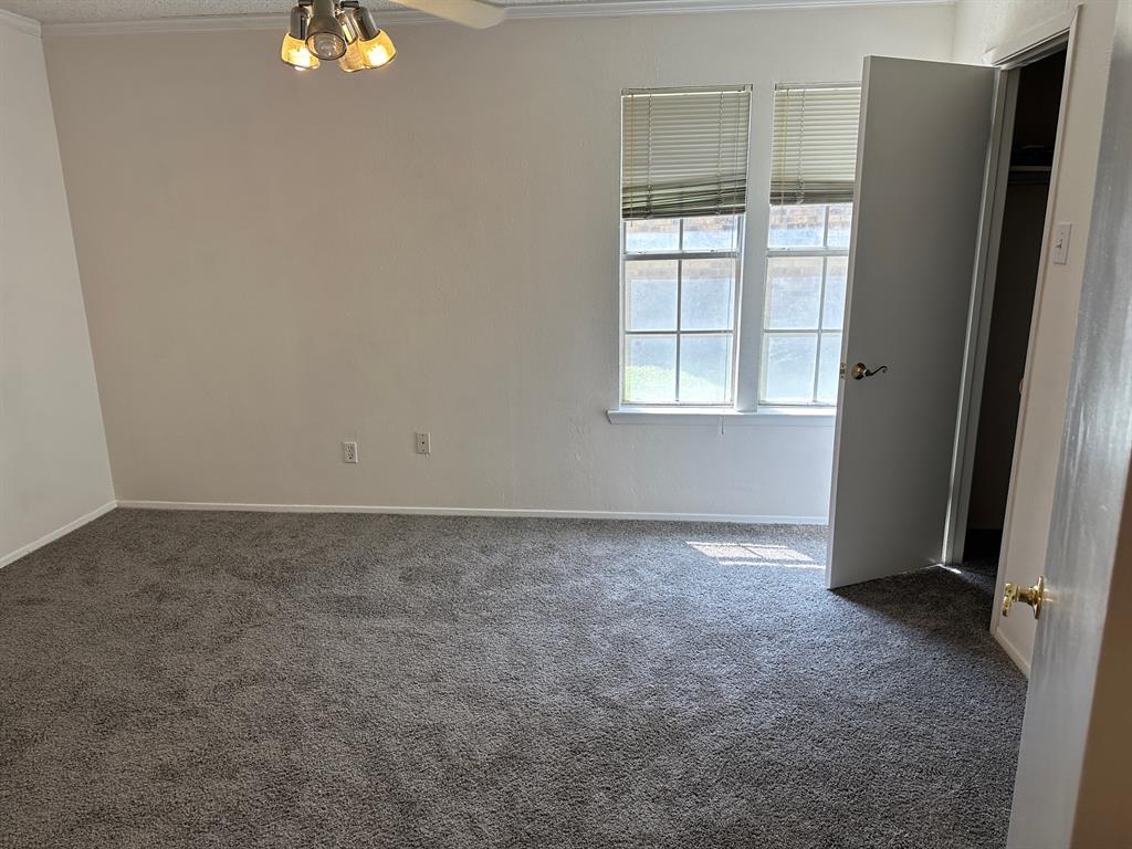 5300 Keller Springs Road, Unit 1090 Dallas, TX 75248 - Photo 4 of 10 Spare room with dark carpet, crown molding, baseboards, and ceiling fan