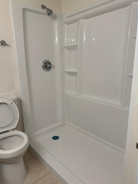 5300 Keller Springs Road, Unit 1090 Dallas, TX 75248 - Photo 6 of 10 Full bath featuring tile patterned floors, a shower stall, and toilet