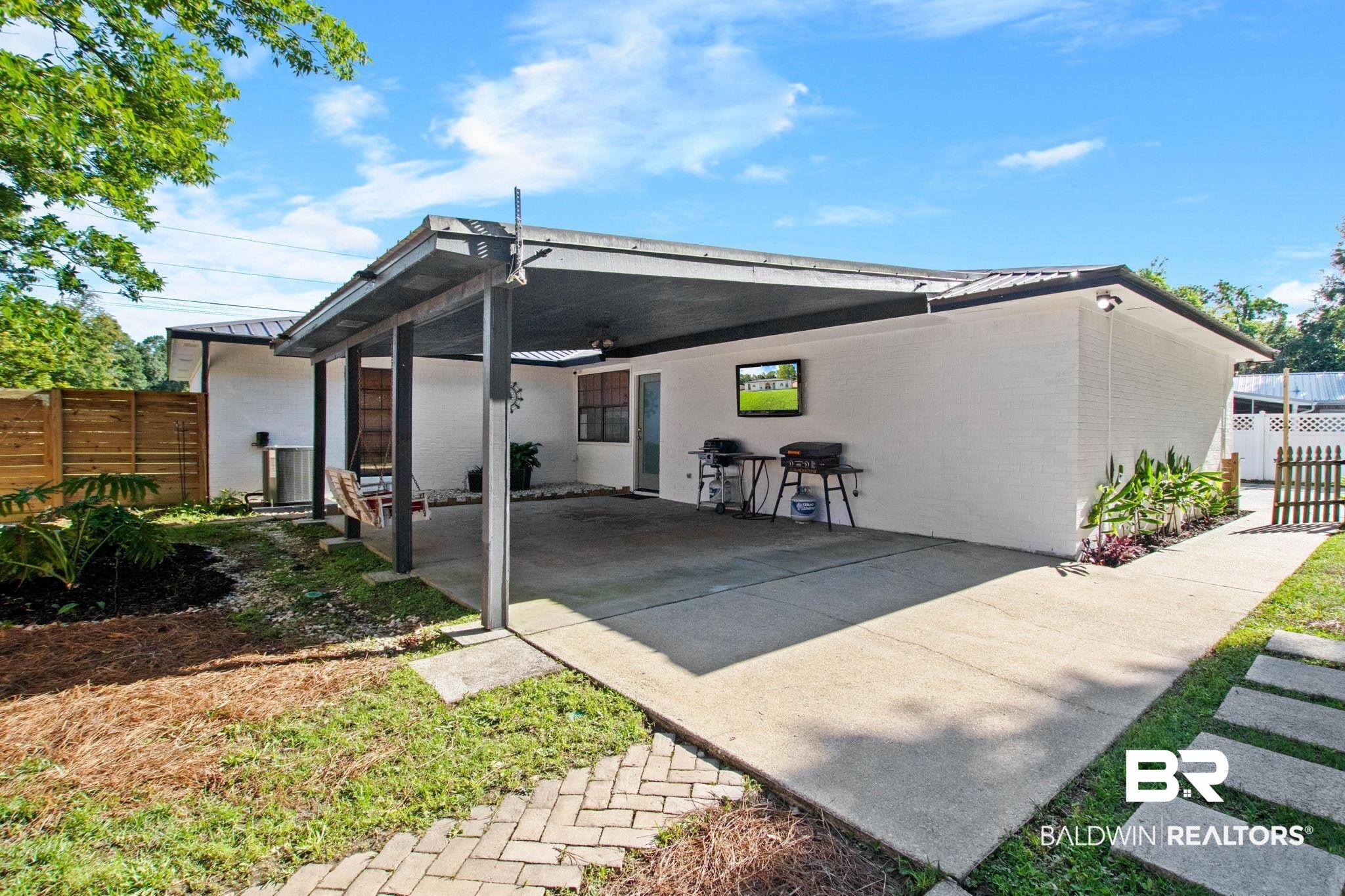 524 Ariel Avenue Foley, AL 36535 - Photo 26 of 37 Covered patio area featuring a concrete slab, exposed beam ceiling, and white painted brick exterior