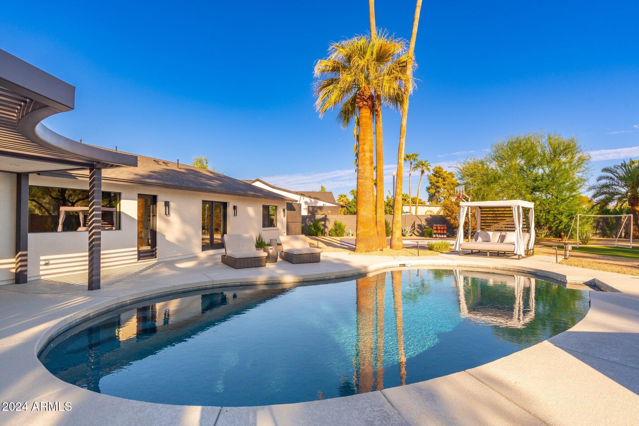 6025 East Charter Oak Road Scottsdale, AZ 85254 - Photo 110 of 115 a view of a swimming pool with a table and chairs