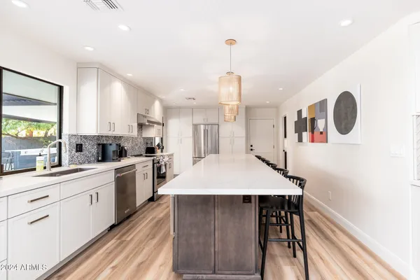 a front view of a house with a yard and palm trees