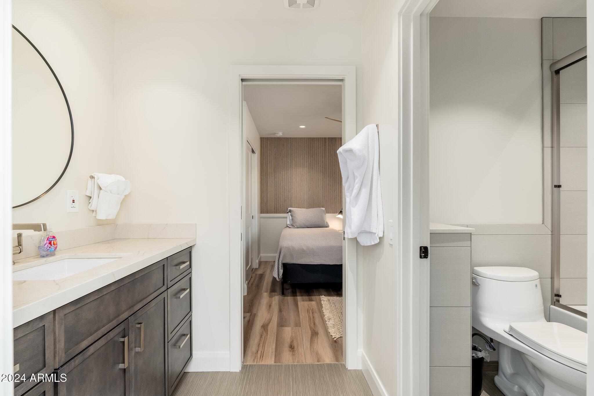6025 East Charter Oak Road Scottsdale, AZ 85254 - Photo 37 of 115 a en suite bathroom with a sink and mirror with toilet
