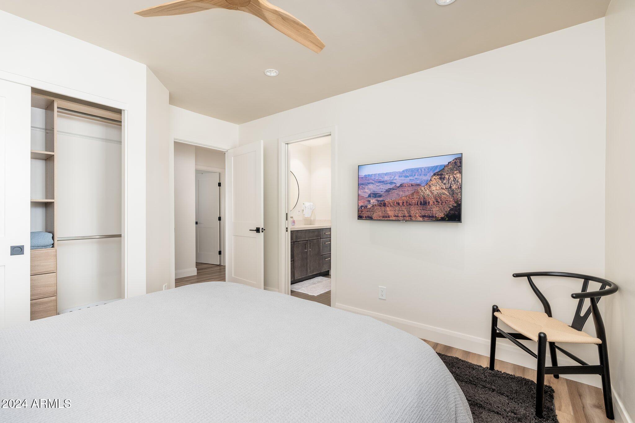 6025 East Charter Oak Road Scottsdale, AZ 85254 - Photo 39 of 115 a bedroom with a large bed and a chandelier
