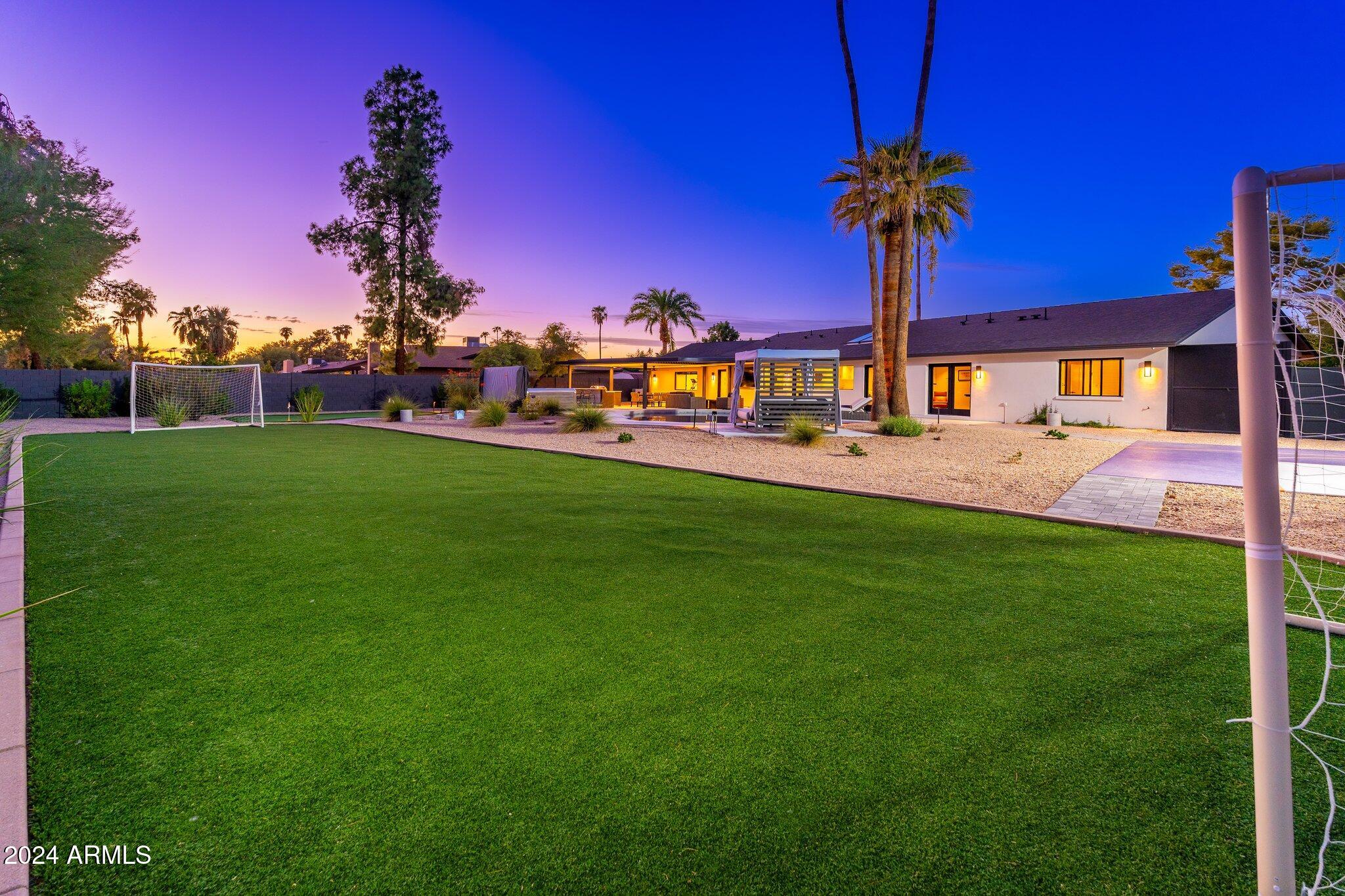 6025 East Charter Oak Road Scottsdale, AZ 85254 - Photo 68 of 115 a front view of a house with a yard and palm trees