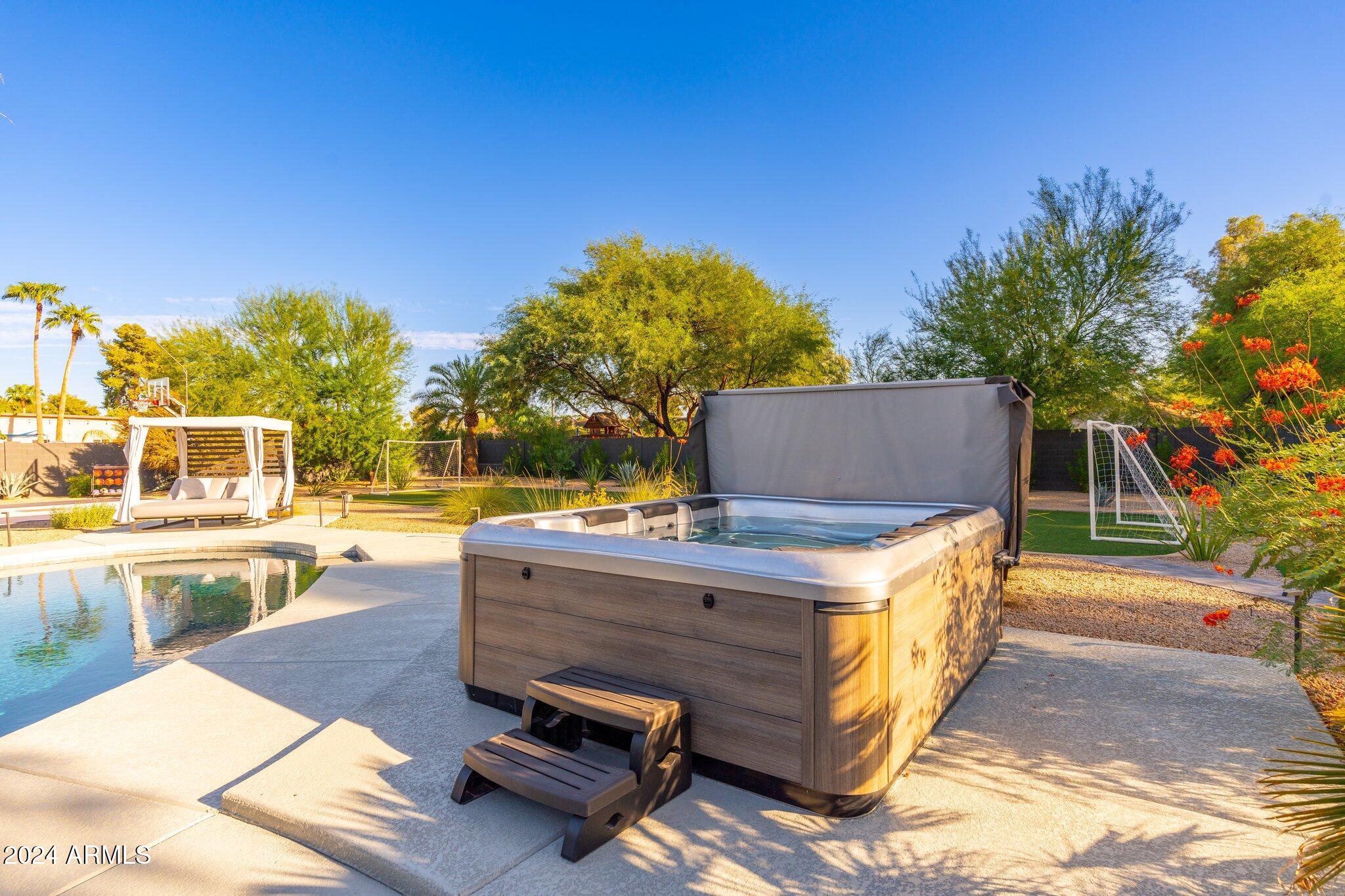6025 East Charter Oak Road Scottsdale, AZ 85254 - Photo 89 of 115 a view of a swimming pool with a lounge chair and a small yard