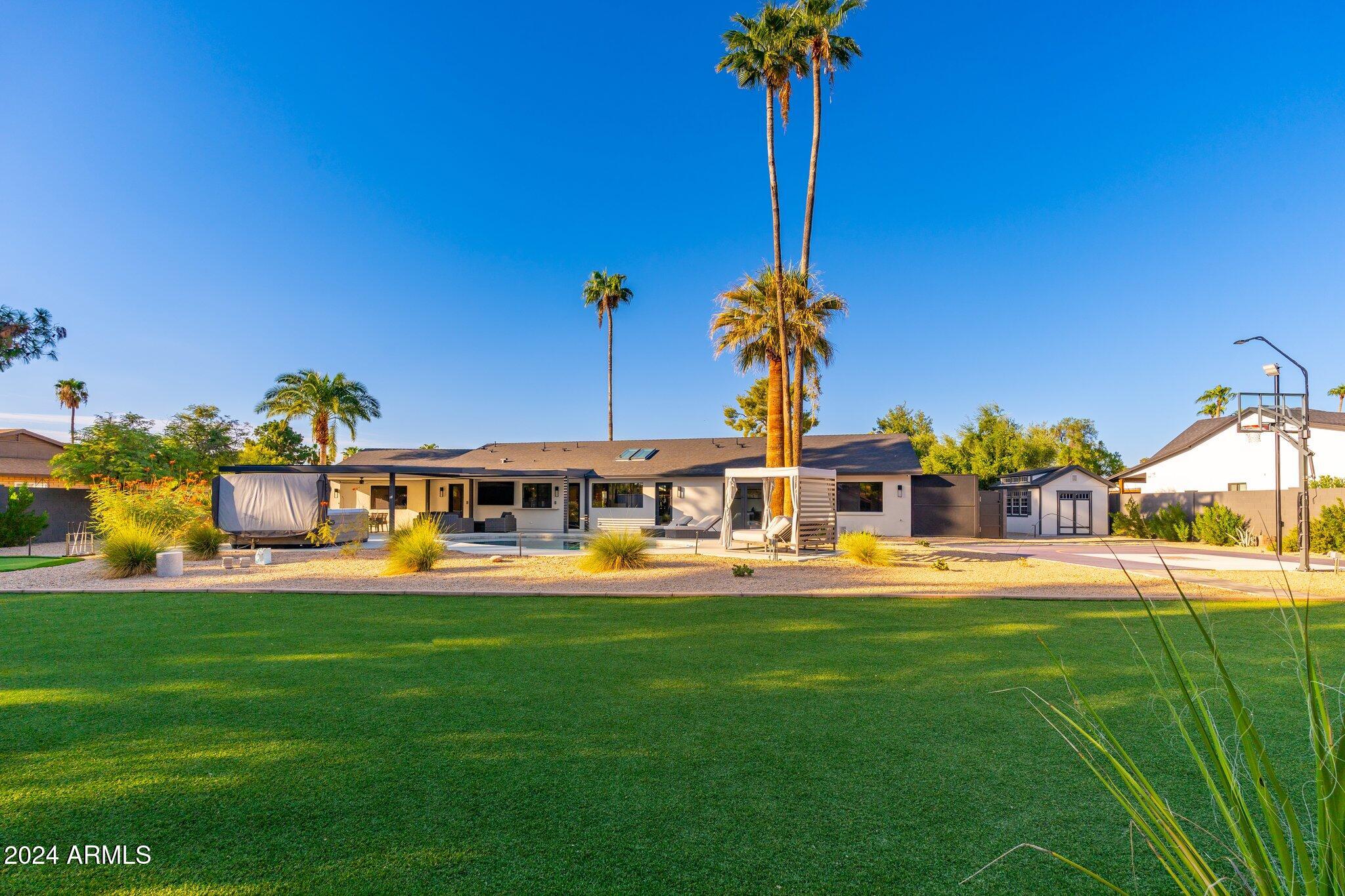 6025 East Charter Oak Road Scottsdale, AZ 85254 - Photo 97 of 115 a front view of a house with a garden and trees