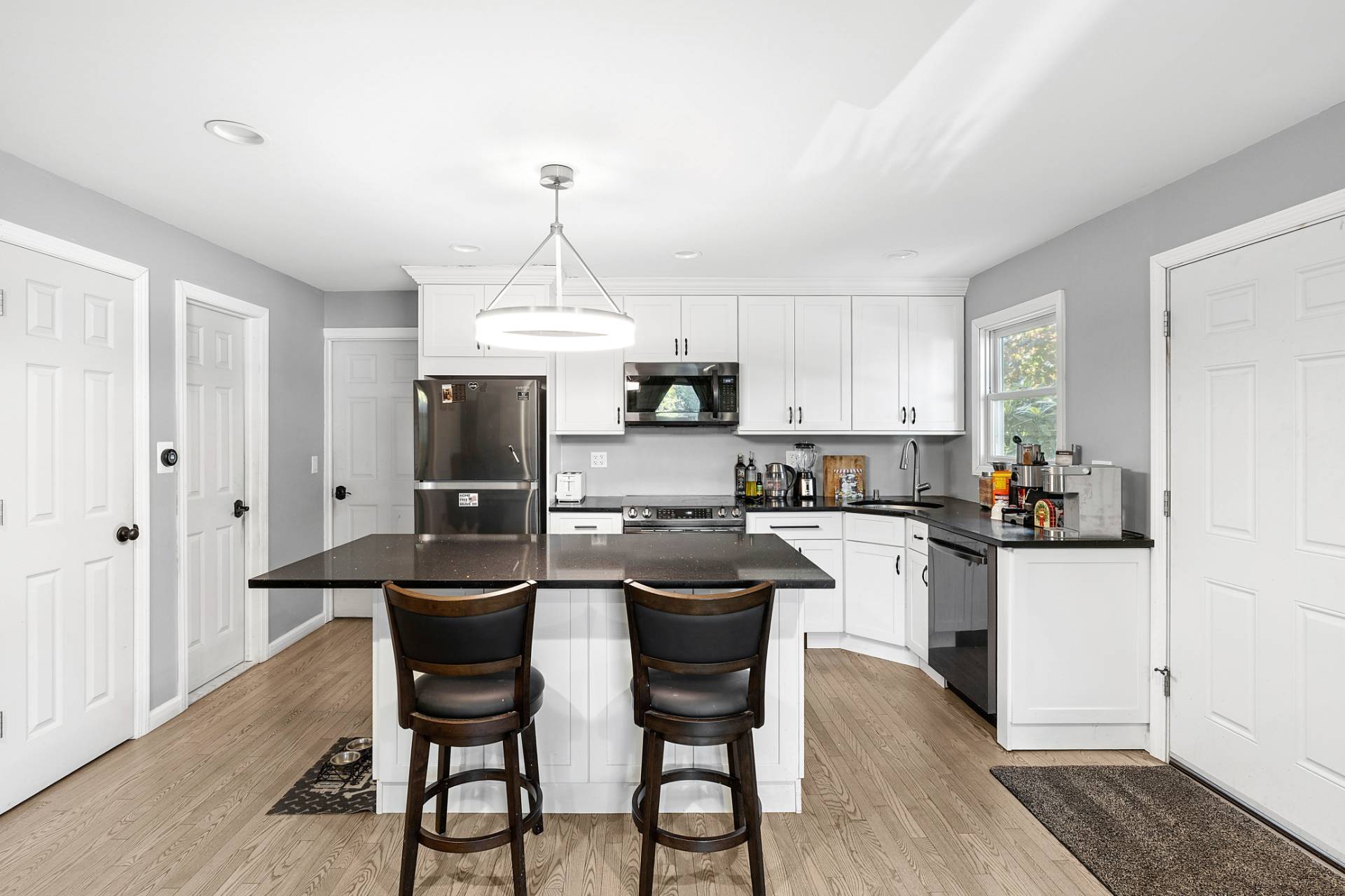201 Herrick Road Southampton, NY 11968 - Photo 17 of 29 a kitchen with kitchen island granite countertop a sink stove and white cabinets