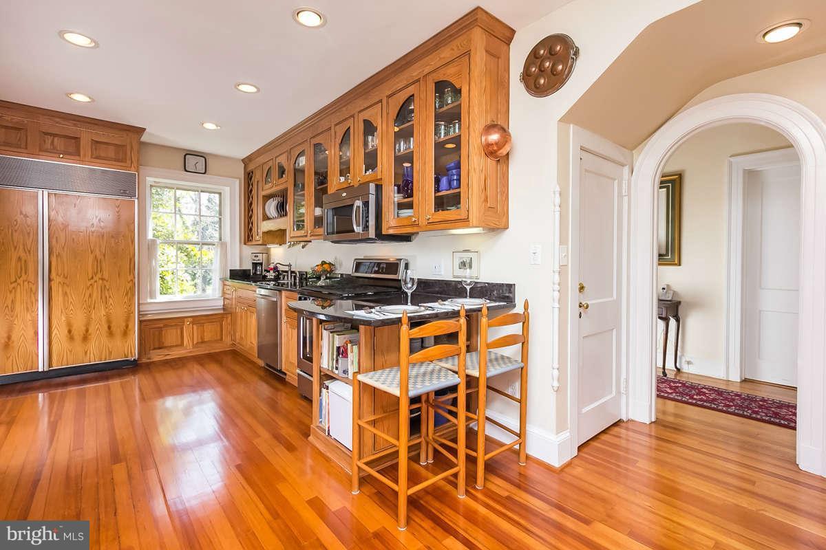 14 East Bishops Road Baltimore, MD 21218 - Photo 8 of 28 a kitchen with stainless steel appliances granite countertop a stove a sink and a refrigerator with wooden floor