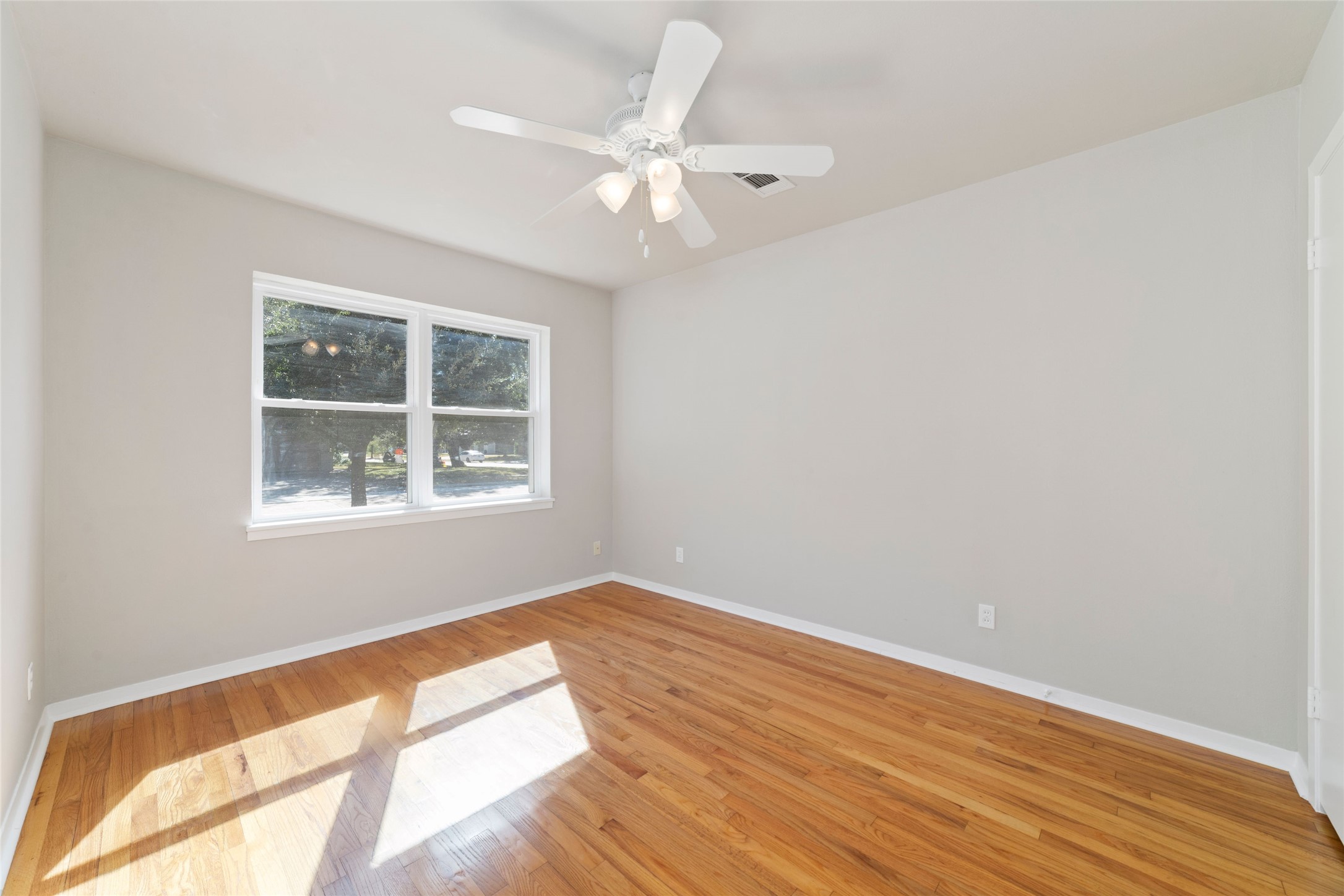11426 Endicott Lane Houston, TX 77035 - Photo 30 of 40 Another view of guest bedroom, unstaged, showing light and ceiling fan and hardwood floors.