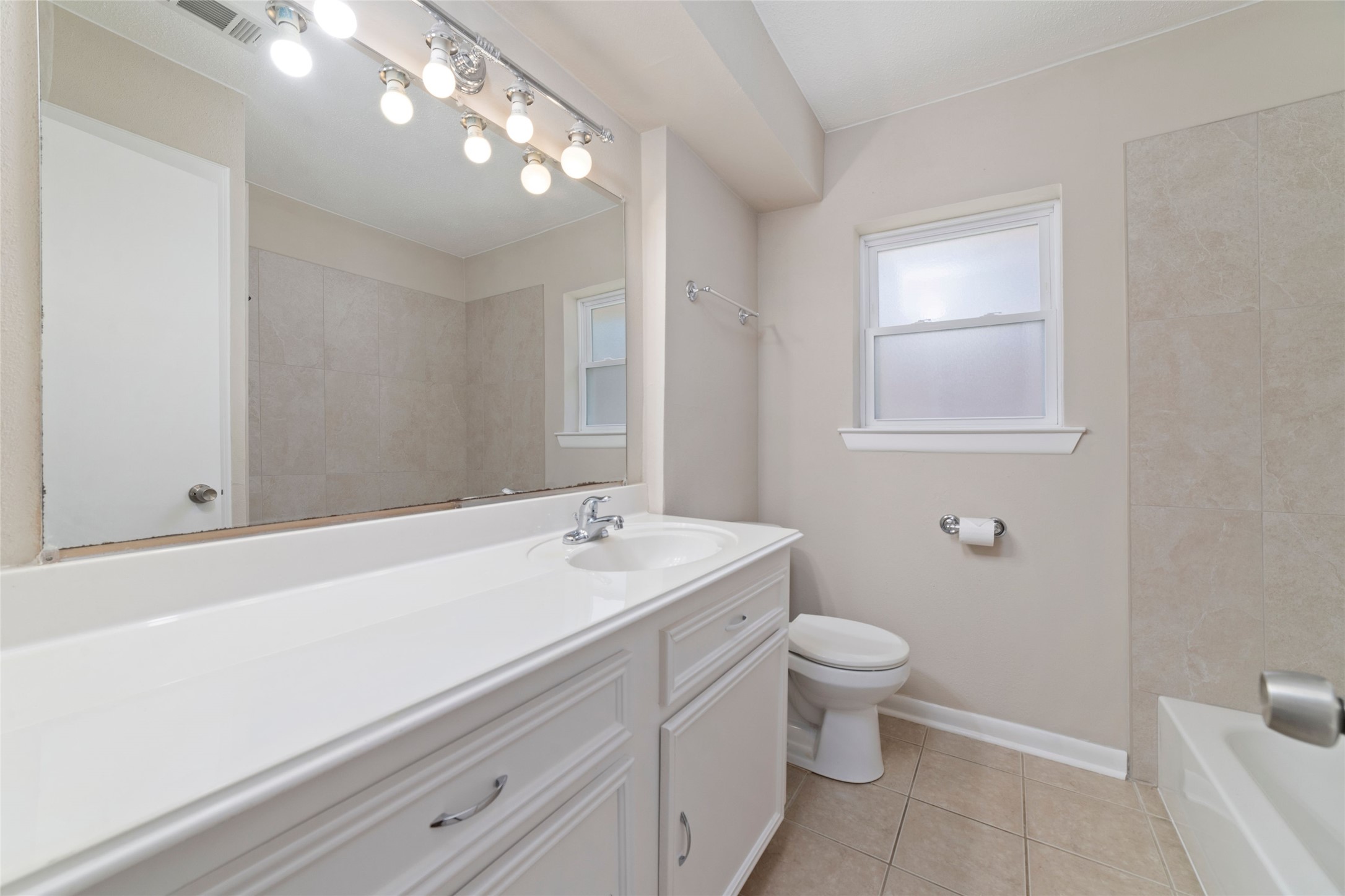 11426 Endicott Lane Houston, TX 77035 - Photo 32 of 40 Updated hall bath with clean countertop and a new tiling in the shower/tub surround.
