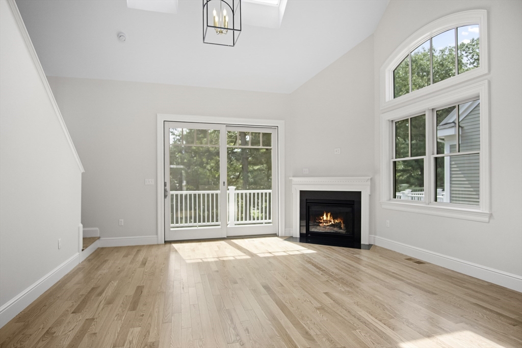 18 Talbot Lane, Unit 18 Reading, MA 01867 - Photo 13 of 33 an empty room with wooden floor fireplace and windows