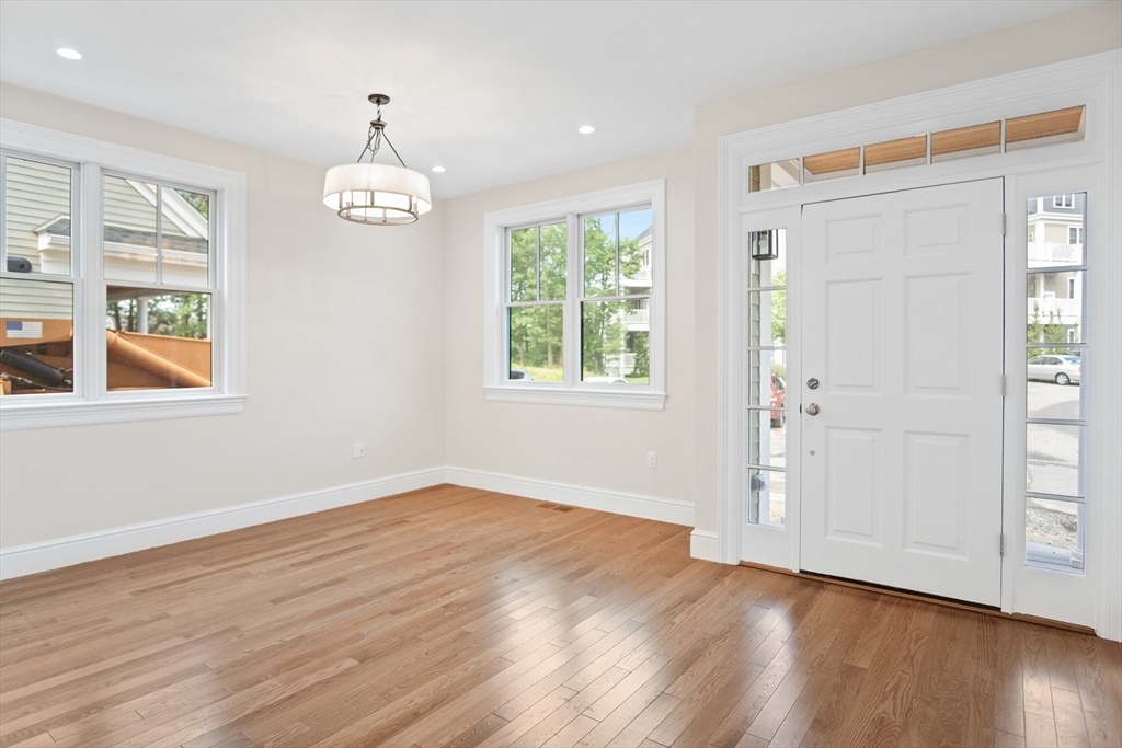 18 Talbot Lane, Unit 18 Reading, MA 01867 - Photo 4 of 33 an empty room with wooden floor chandelier and windows