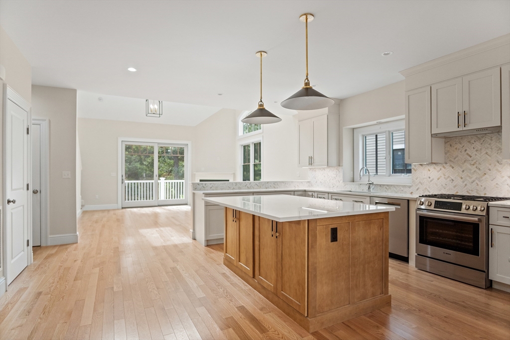 18 Talbot Lane, Unit 18 Reading, MA 01867 - Photo 5 of 33 a kitchen with stainless steel appliances granite countertop a stove and a wooden floor