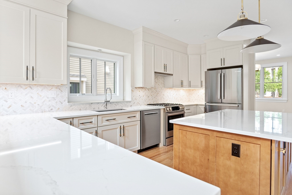 18 Talbot Lane, Unit 18 Reading, MA 01867 - Photo 8 of 33 a kitchen with stainless steel appliances granite countertop a sink stove and refrigerator