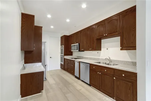 a large kitchen with stainless steel appliances kitchen island granite countertop a sink and cabinets