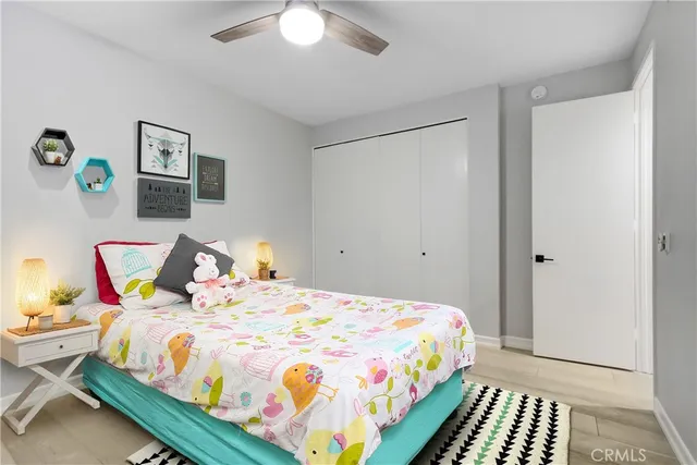 a bedroom with a bed and a lamp on dresser