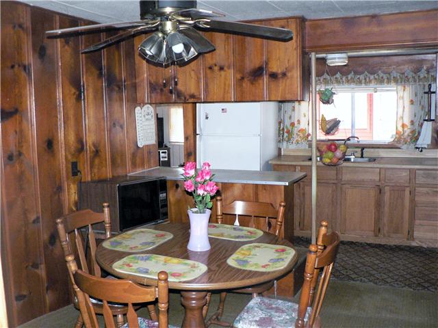 219 Summitville Road Manchester, TN 37355 - Photo 6 of 13 Eat in kitchen with paneled walls, ceiling fan, food bar and butcher block counter tops.