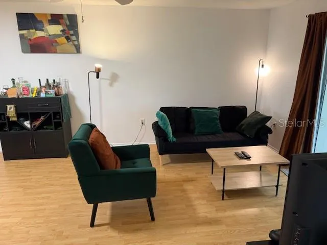 a living room with furniture and a wooden floor