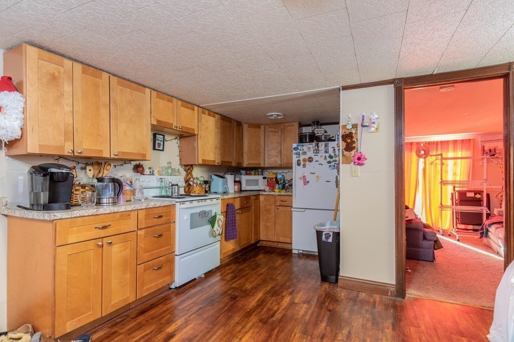 48 West Broadway Gardner, MA 01440 - Photo 15 of 21 a kitchen with refrigerator cabinets and wooden floor