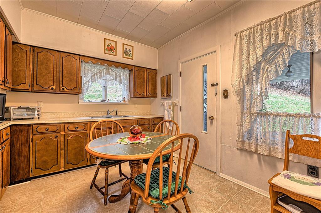 111 Dixonville Road Clymer, PA 15728 - Photo 6 of 27 a kitchen with stainless steel appliances a sink a stove a dining table and chairs