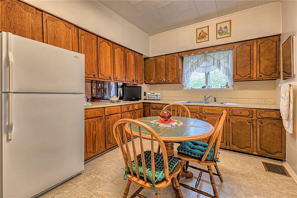 111 Dixonville Road Clymer, PA 15728 - Photo 8 of 27 a kitchen with stainless steel appliances granite countertop a refrigerator a sink a stove and white cabinets