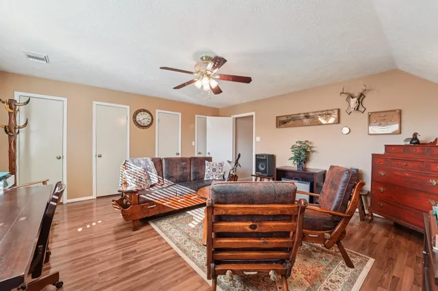 a living room with furniture a ceiling fan and a rug