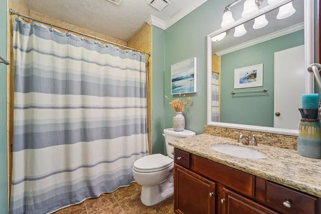 a bathroom with a granite countertop sink toilet and shower