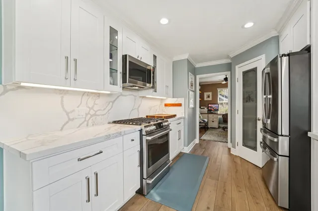 a kitchen with stainless steel appliances a stove microwave and refrigerator