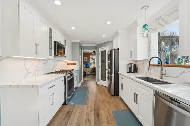 a kitchen with stainless steel appliances a sink stove and refrigerator