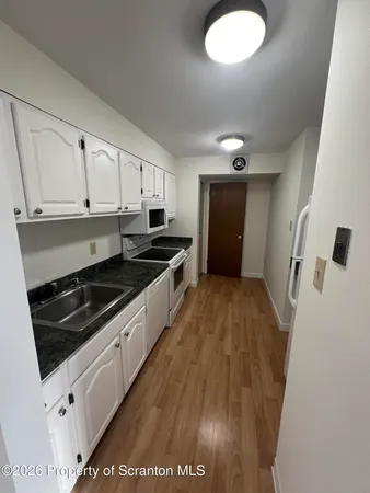 a kitchen with granite countertop a stove and a refrigerator