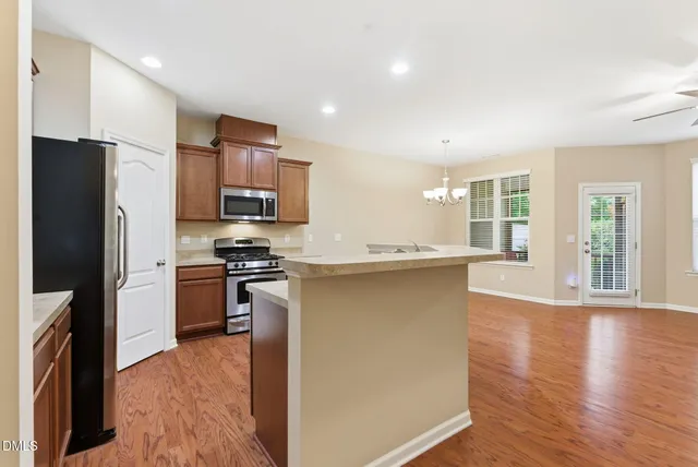 a kitchen with stainless steel appliances granite countertop a sink stove microwave and refrigerator