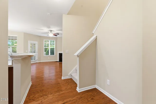 a view of a hallway with wooden floor and staircase