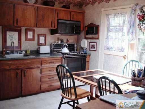 78 Harmon Road Edison, NJ 08837 - Photo 4 of 8 a kitchen with stainless steel appliances granite countertop a stove top oven a sink a dining table and chairs