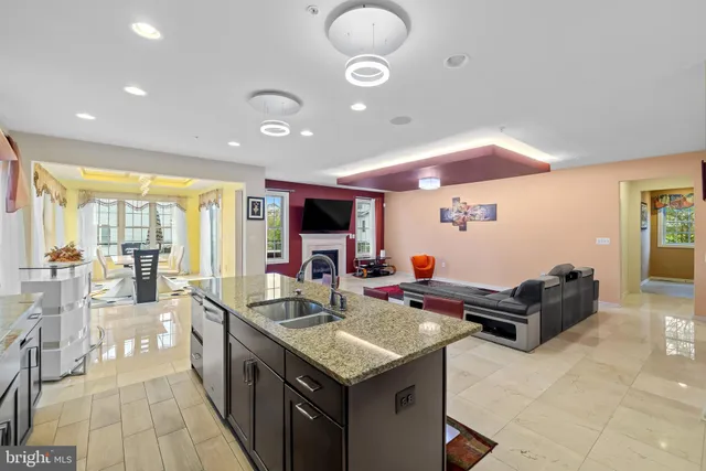 a living room with furniture kitchen view and a large window