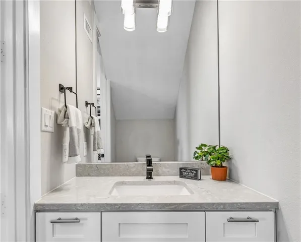 a bathroom with a granite countertop sink a mirror and vanity