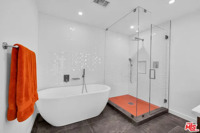 a bedroom with a bed and a lamp on dresser