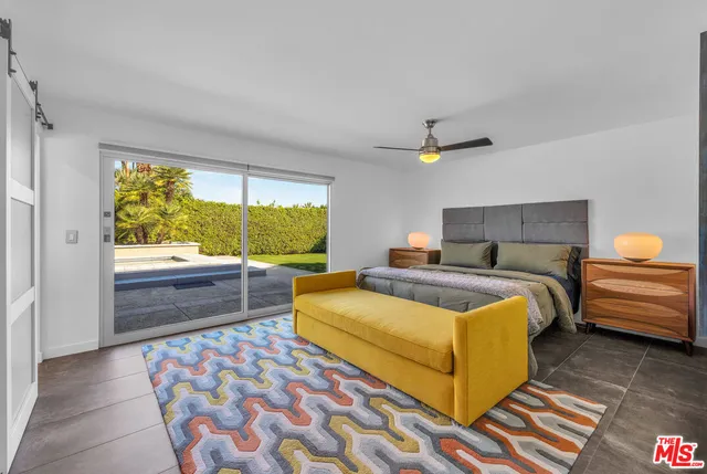 a bedroom with a bed a couch and a dresser next to a window