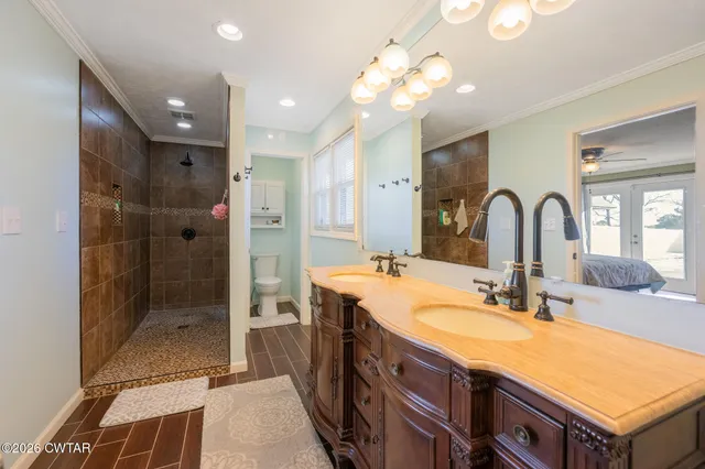 a bed sitting in a spacious bedroom next to a window