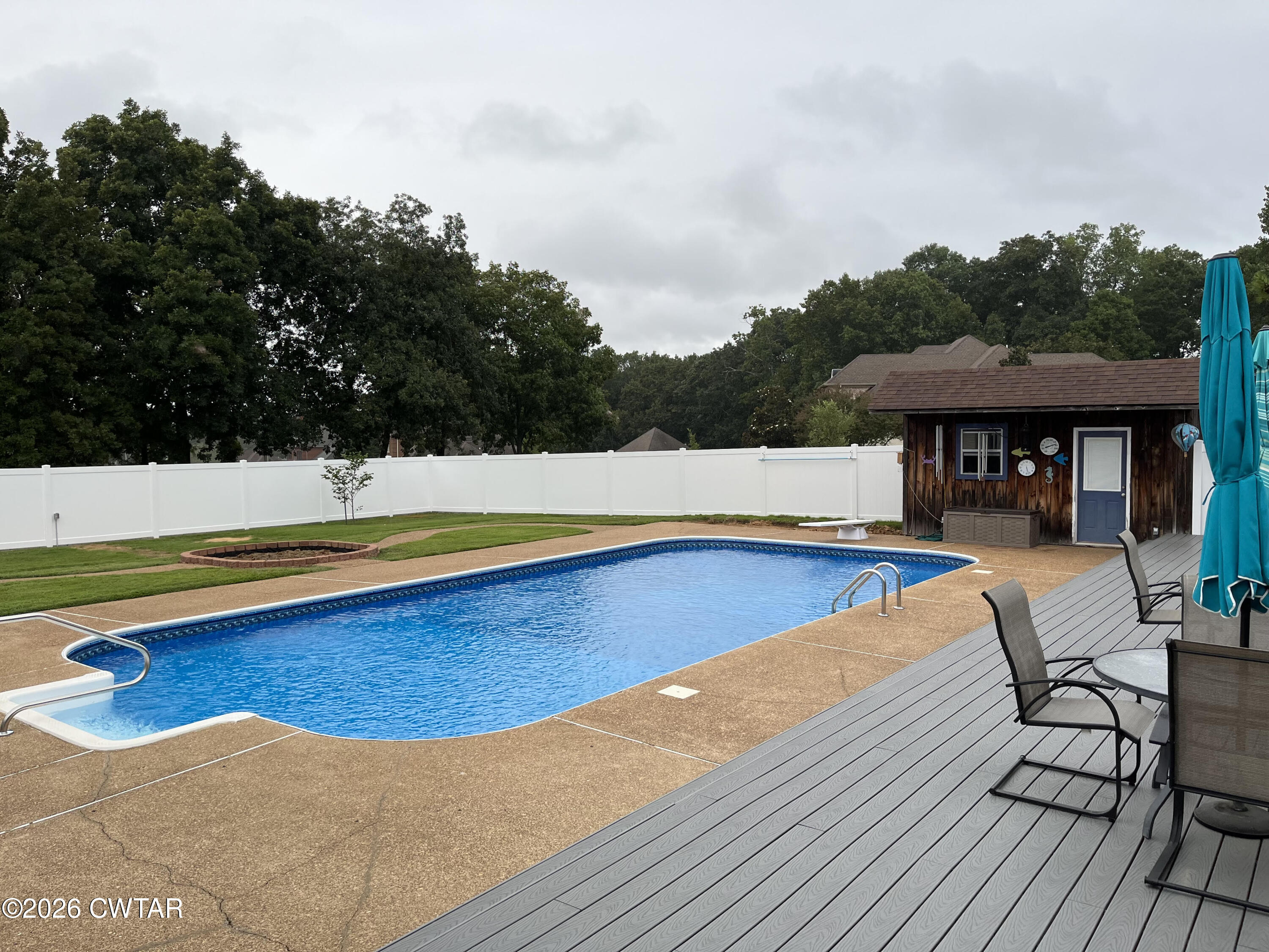 491 Tara Lane Huntingdon, TN 38344 - Photo 48 of 49 a view of swimming pool with lounge chair and dinning table under an umbrella