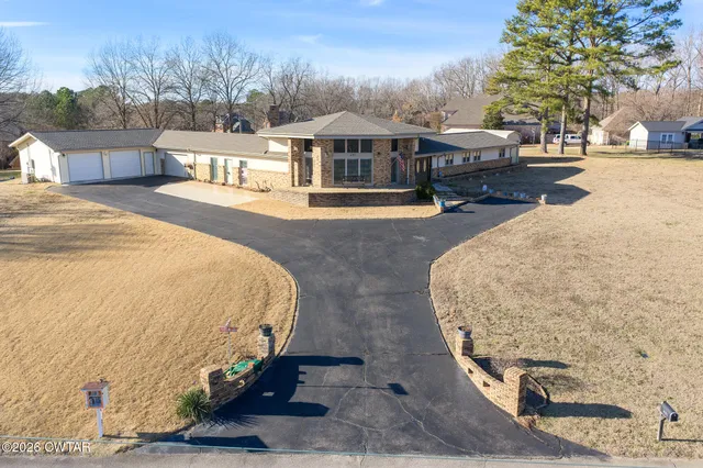 a swimming pool with outdoor seating and yard in the back