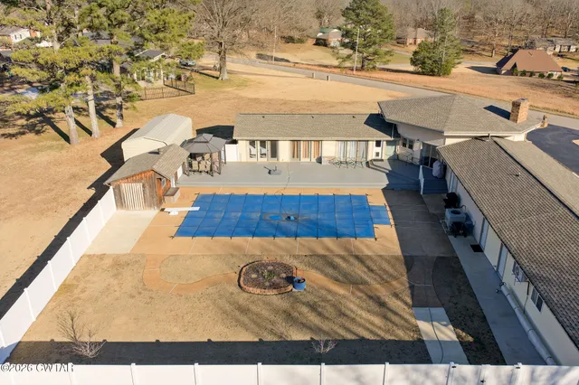 a view of a swimming pool with seating area and trees around